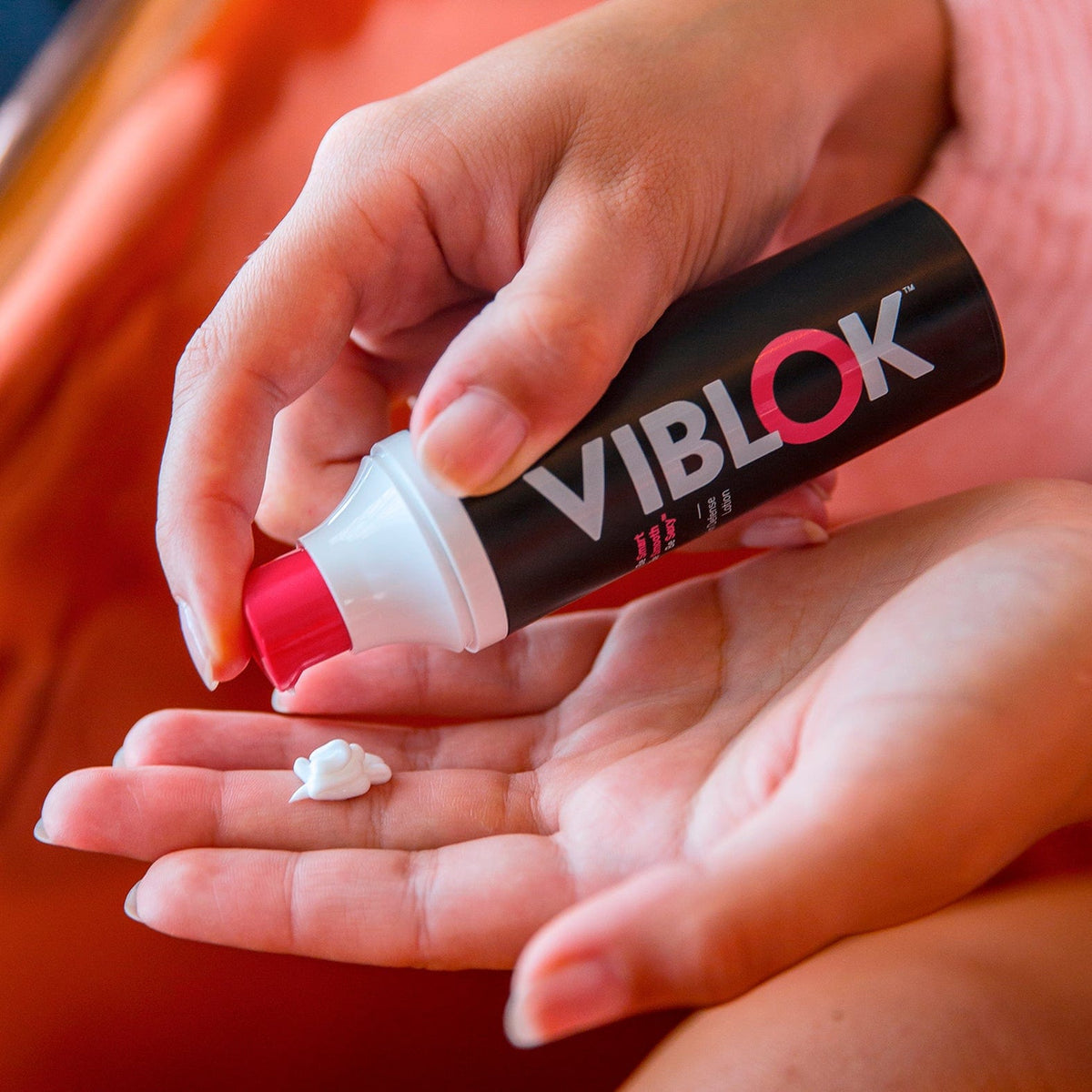 Woman's hands pumping the 30 ml Skin Defense Lotion in her hand