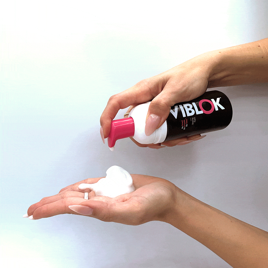 VIBLOK Shaving Foam bottle pumping foam rich in texture over a girl hand